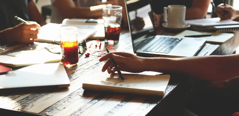 People working at a table going through ad tips for marketers